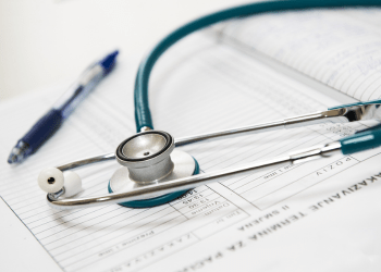 Stethoscope and pen on a notebook in a healthcare training setting