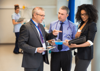 Professionals discussing healthcare equipment management during a consulting session