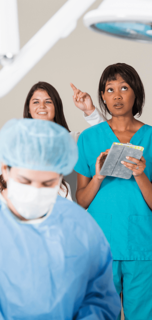 Healthcare professionals participating in a practical training session under surgical lighting