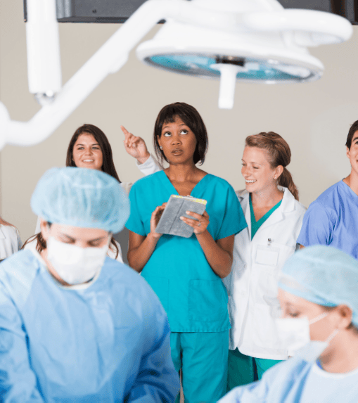 Healthcare professionals participating in a practical training session under surgical lighting